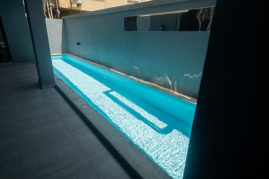 Brum Height 6: Outdoor swimming pool beside a blue perimeter wall